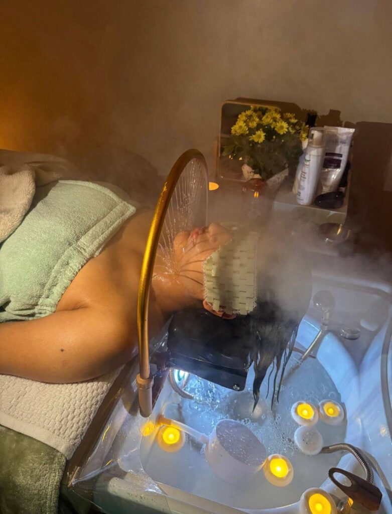 Client enjoying a luxury Japanese head spa treatment with steam therapy, scalp massage, candles, and calming spa atmosphere designed for relaxation and scalp wellness.