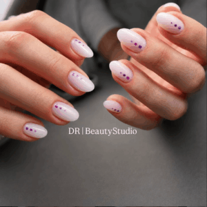 Pink Polygel manicure with square-shaped nails and white polka dot nail art by DR Beauty Studio.