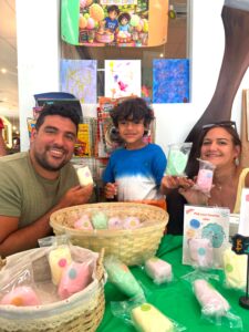 Little CEOs student with his family showcasing his mini business at a youth entrepreneurship fair after participating in Future Minds’ bilingual English-Spanish business program.