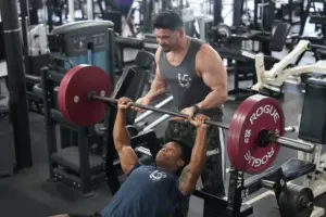 Personal trainer spotting a member during a bench press workout at University Fitness Center.